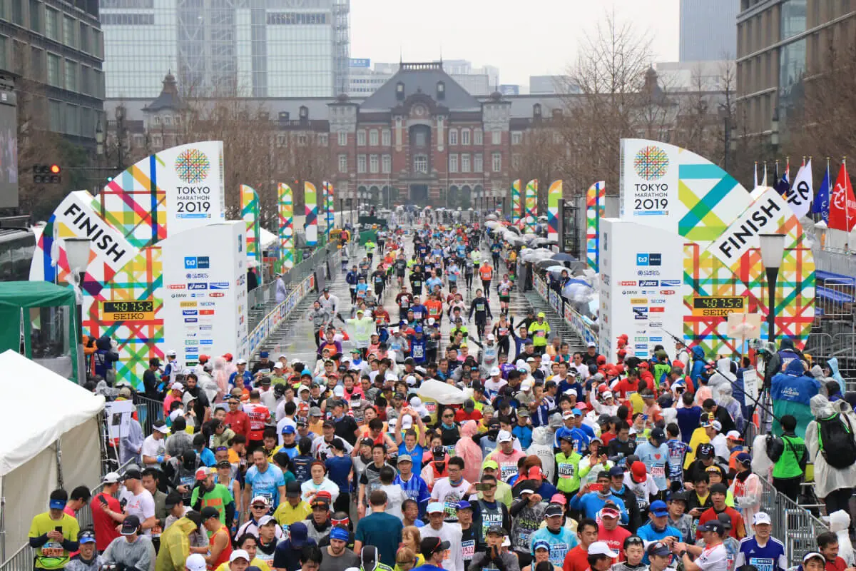 Participants cross the Tokyo Marathon finish line